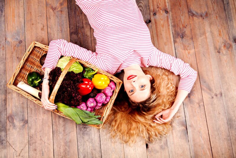 Niña cargando una canasta de verduras